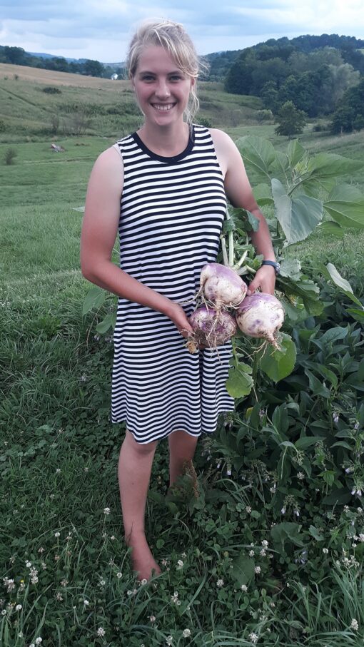 Lydia holding a bunch of Purple Top Turnips.