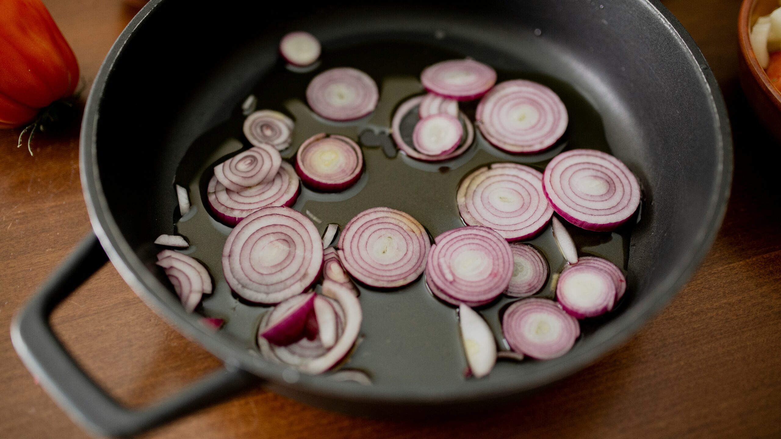 Slices of onions cooking in a pan.