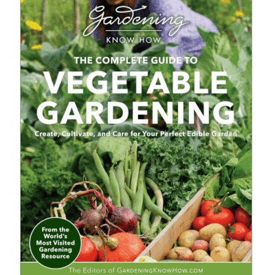 A gardener tends leafy vegetables beside a wooden crate of fresh tomatoes, radishes, and greens—cover of The Complete Guide to Vegetable Gardening by GardeningKnowHow.